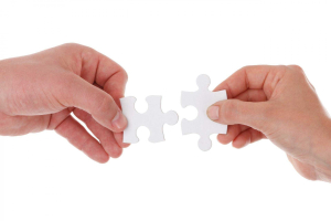 Zwei Hände mit jeweils einem Puzzleteil für fylr-Partner werden