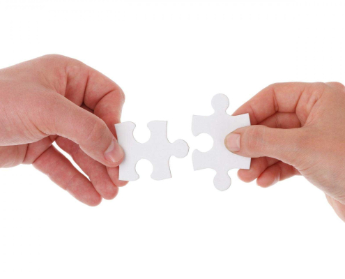 Two hands each with a puzzle piece to become fylr partners