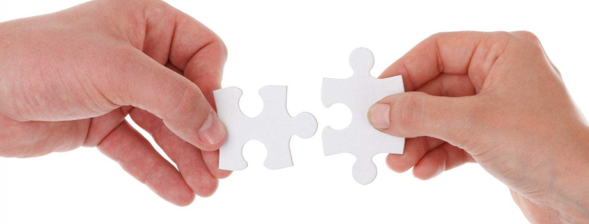 Zwei Hände mit jeweils einem Puzzleteil für fylr-Partner werden